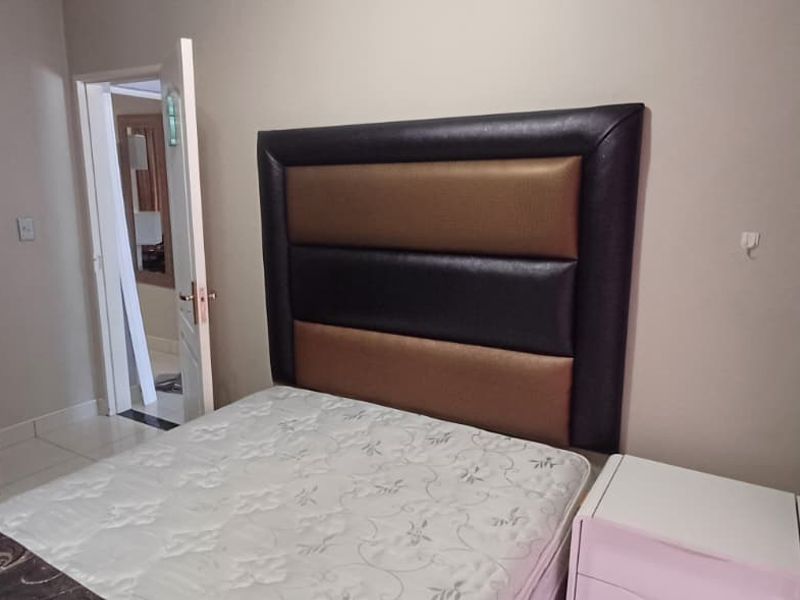 A bedroom featuring tiled flooring and a built-in wardrobe, with a view into an adjacent room through an open doorway.