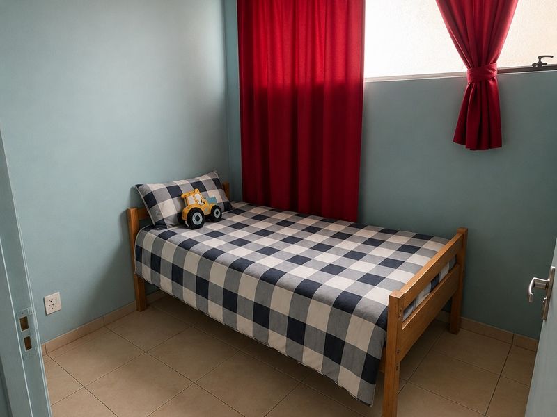 A compact bedroom featuring tiled flooring, a timber-paneled ceiling, and a top-hung window with red curtains.