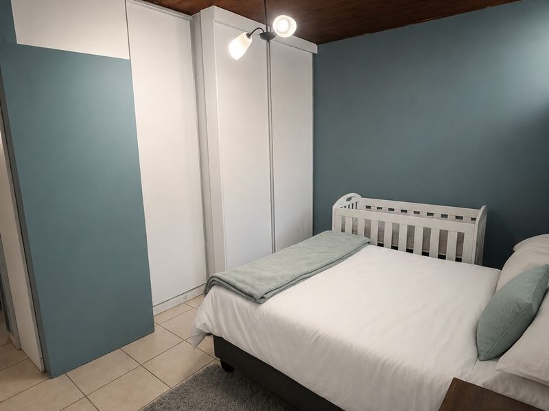 A bedroom featuring tiled flooring, built-in cupboards, and a distinctive timber-paneled ceiling, providing a functional and cozy living space.
