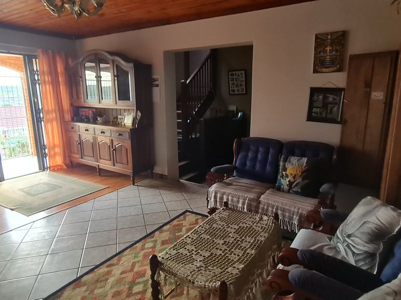 Open plan living and dining area featuring a combination of timber ceilings, ceramic tiling, and laminate flooring with access to an outdoor patio.