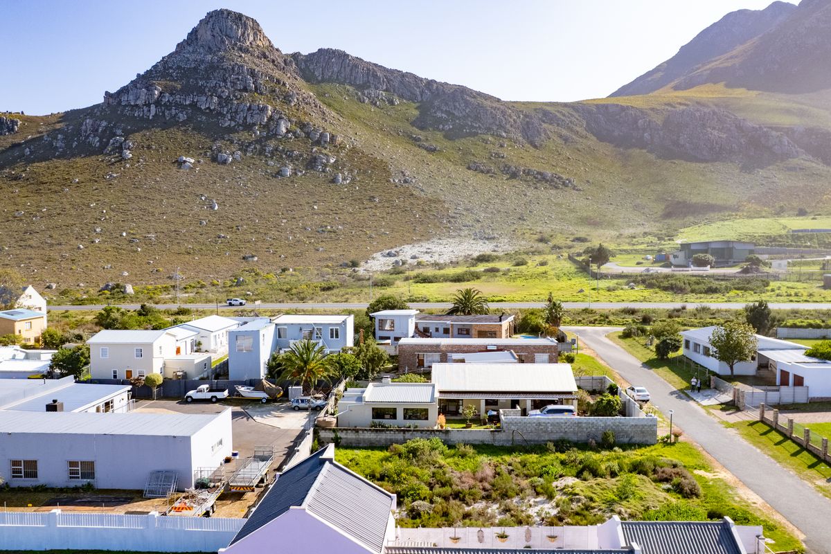 An aerial view of a residential neighborhood set against a scenic mountain landscape, showcasing the property's location and surrounding environment.