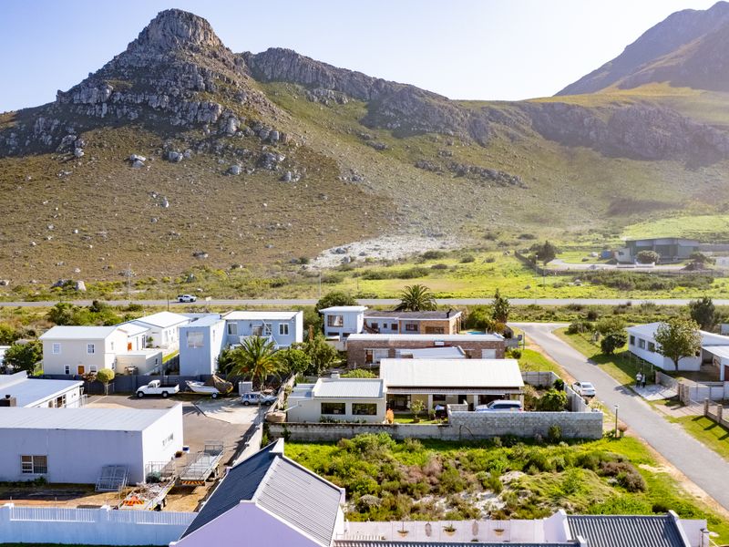 An aerial view of a residential neighborhood set against a scenic mountain landscape, showcasing the property's location and surrounding environment.