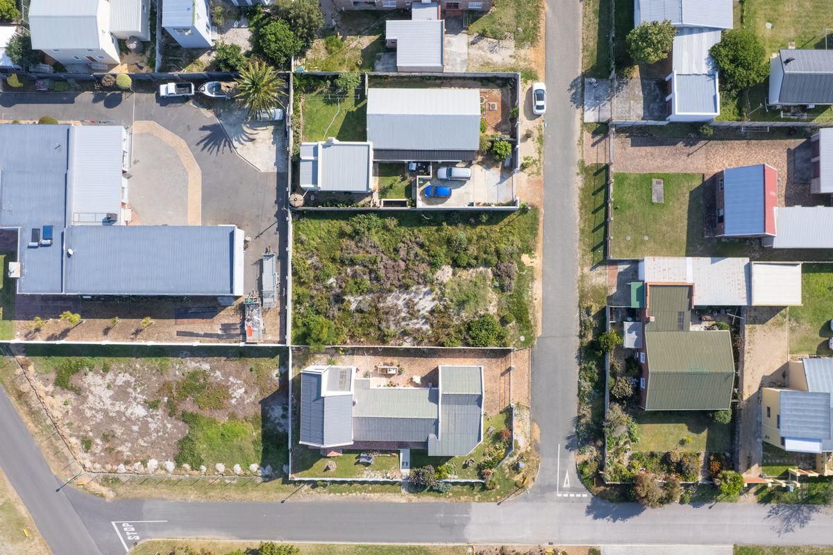Aerial view of a residential vacant land plot situated within an established neighborhood, offering clear street access and defined boundary lines.