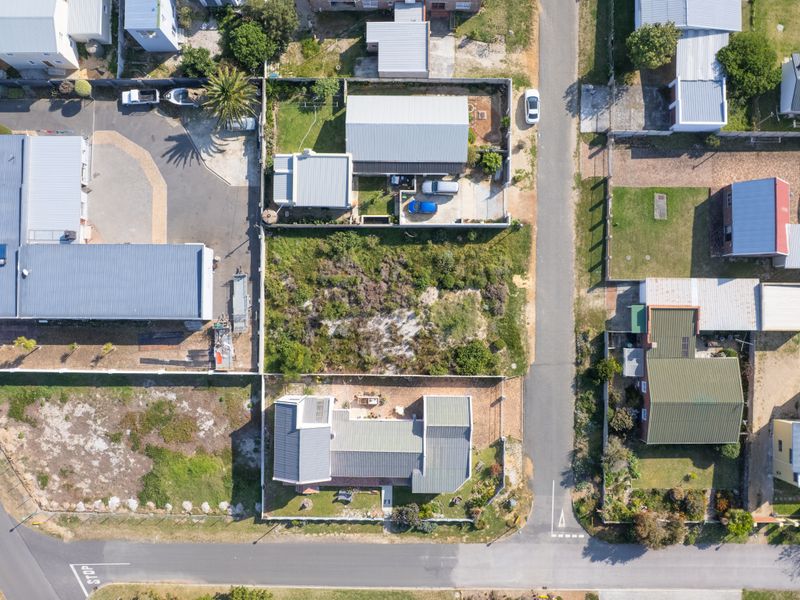 Aerial view of a residential vacant land plot situated within an established neighborhood, offering clear street access and defined boundary lines.
