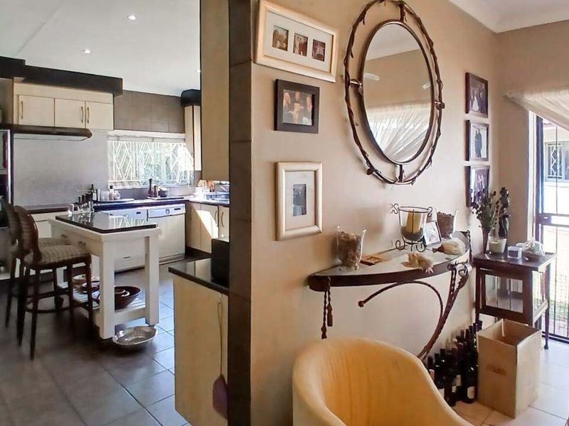 Open plan living and kitchen area featuring tiled flooring, modern cabinetry, and a central kitchen island, creating a functional and connected living space.