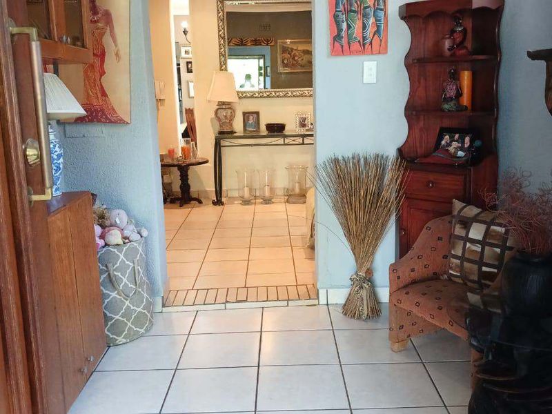 Entrance hall featuring tiled flooring and a wooden door, leading into the main living area of the home.