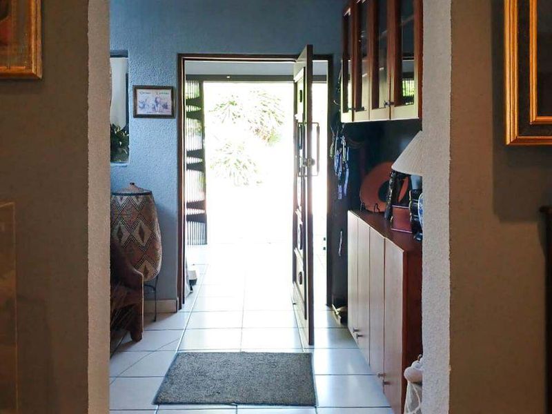 Entrance foyer featuring tiled flooring and built-in wooden cabinetry, providing a functional transition space into the home.