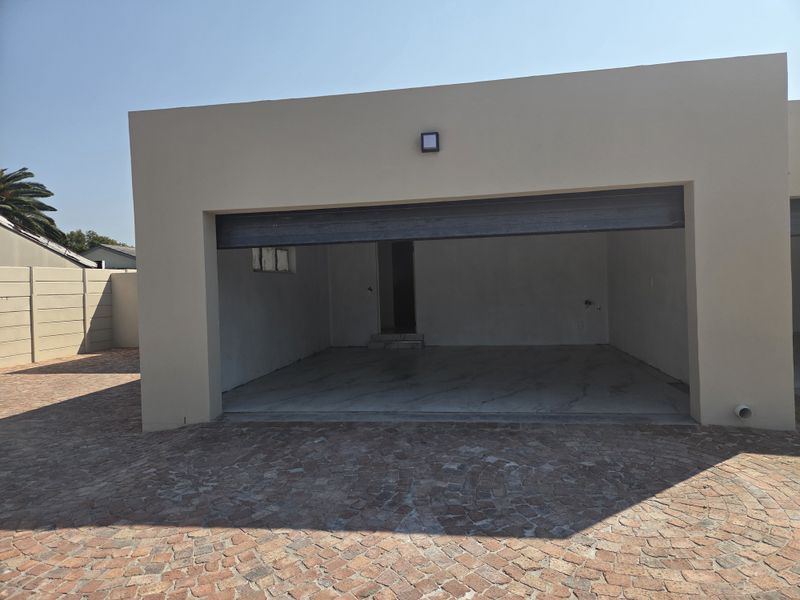 A detached garage structure featuring a paved driveway and open entrance, providing secure parking space.