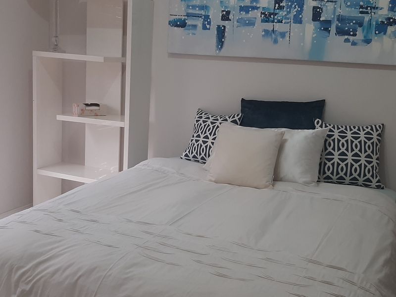 A well-maintained bedroom featuring built-in shelving and venetian blinds, providing a clean and functional living space.