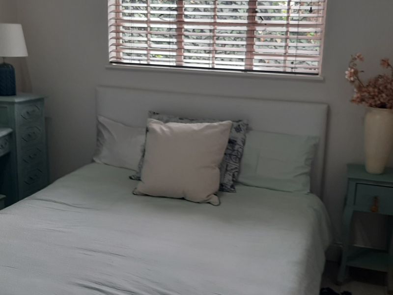 A cozy bedroom featuring a window with fitted venetian blinds, providing natural light and a comfortable living space.