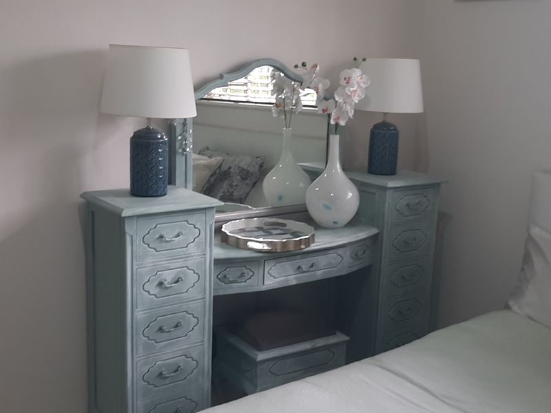 A cozy bedroom featuring neutral walls and venetian blinds, providing a comfortable and well-lit sleeping space.
