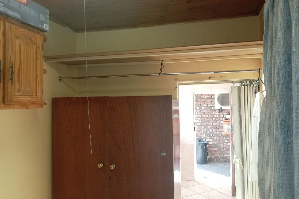 Bedroom featuring a built-in wardrobe with hanging rail and shelving, complemented by a timber ceiling and direct access to an outdoor area.