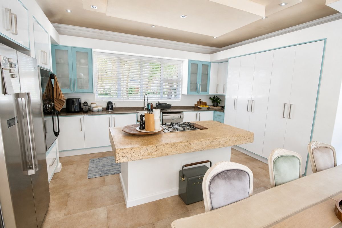 Modern kitchen featuring a central island with a gas cooktop, ample built-in cabinetry, stone countertops, and recessed ceiling lighting.