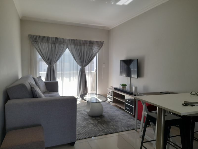 Open plan living area featuring tiled flooring and a sliding glass door leading to an outdoor space.