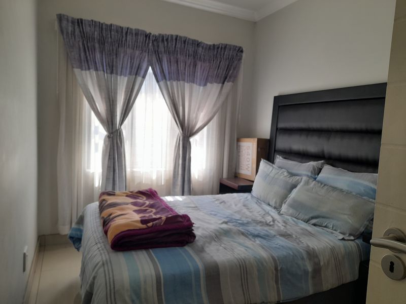 A standard bedroom featuring tiled flooring and window treatments, providing a functional and comfortable sleeping space.