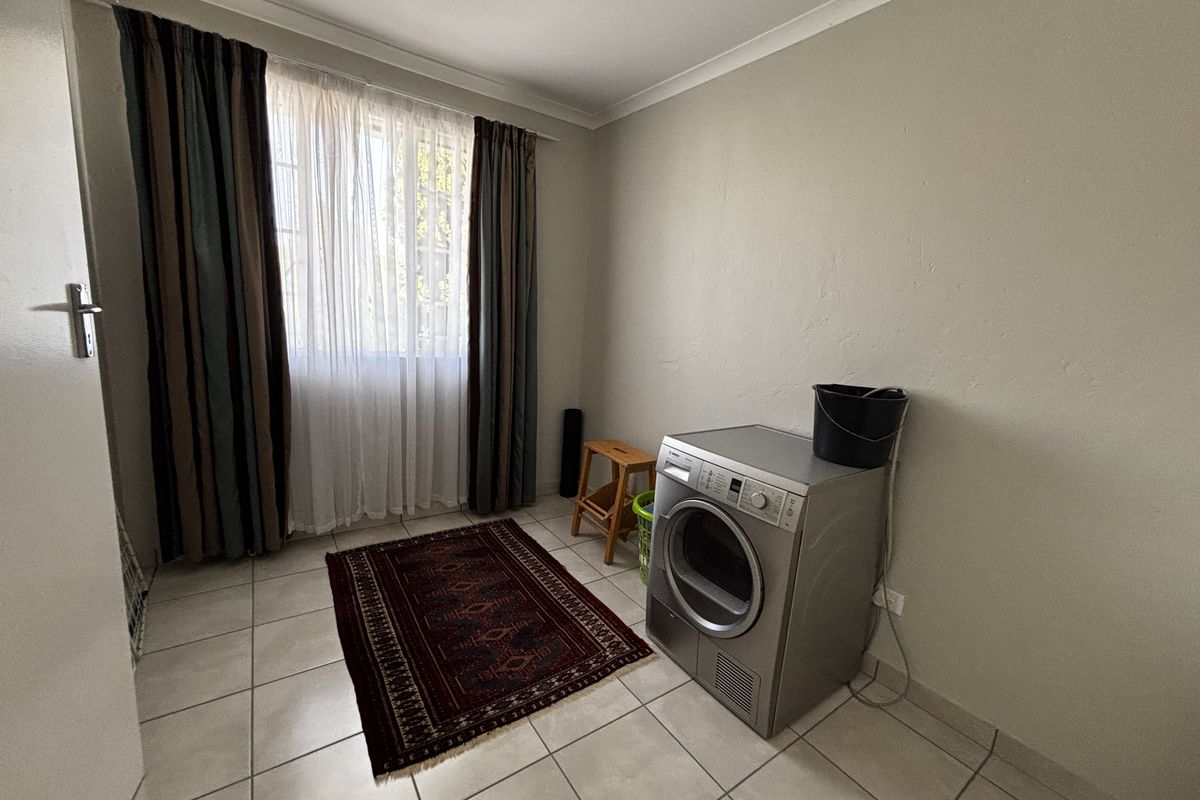 A functional laundry room featuring tiled flooring and neutral wall finishes, providing a clean and practical space for utility needs.