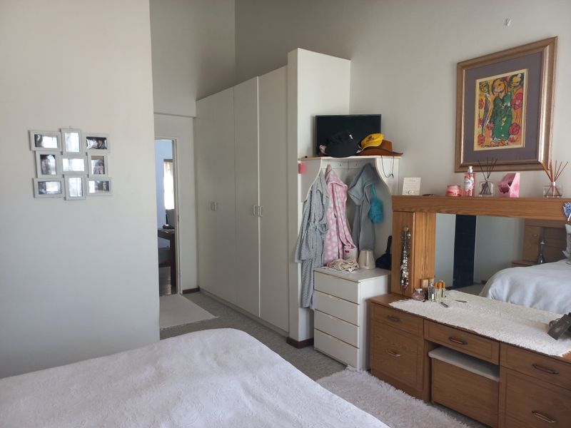 A bedroom featuring built-in white wardrobes and carpeted flooring, providing functional storage space.