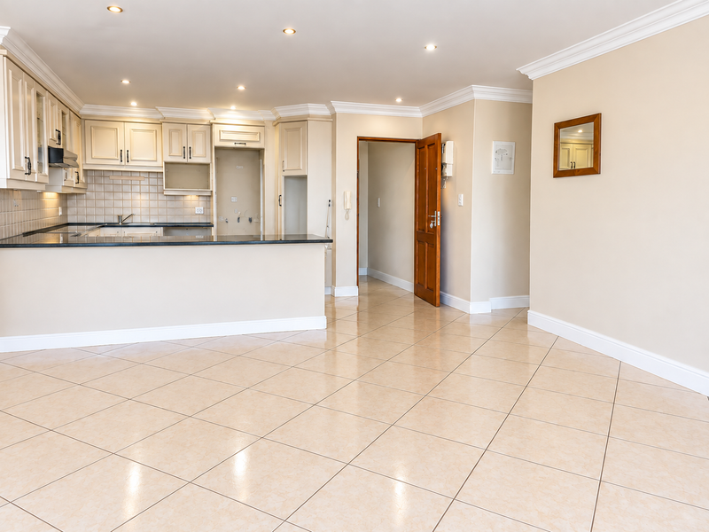 Spacious open-plan living area featuring tiled floors, recessed lighting, and a functional kitchen with granite countertops and ample cabinetry.