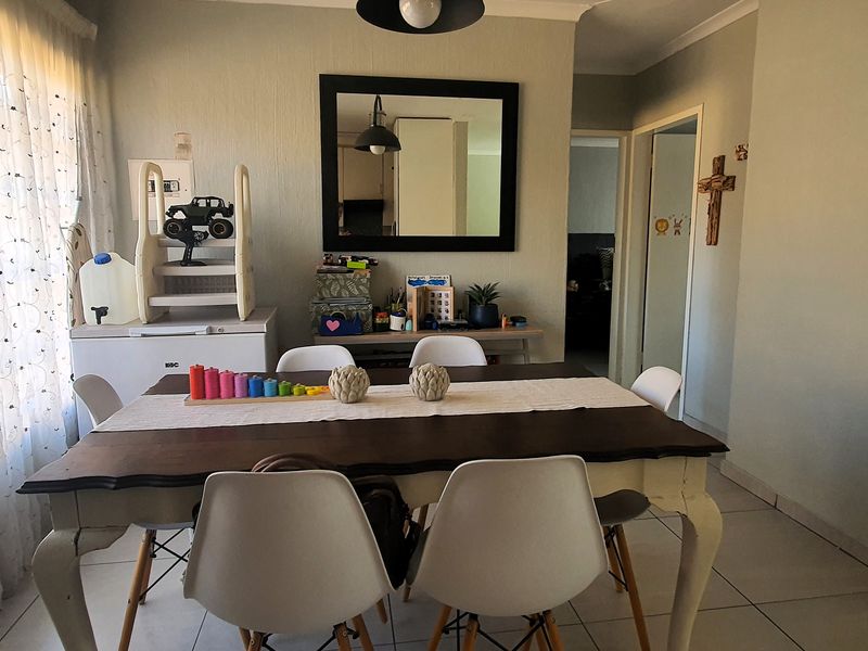A dining room featuring tiled flooring and cove cornicing, with natural light provided by a large window.