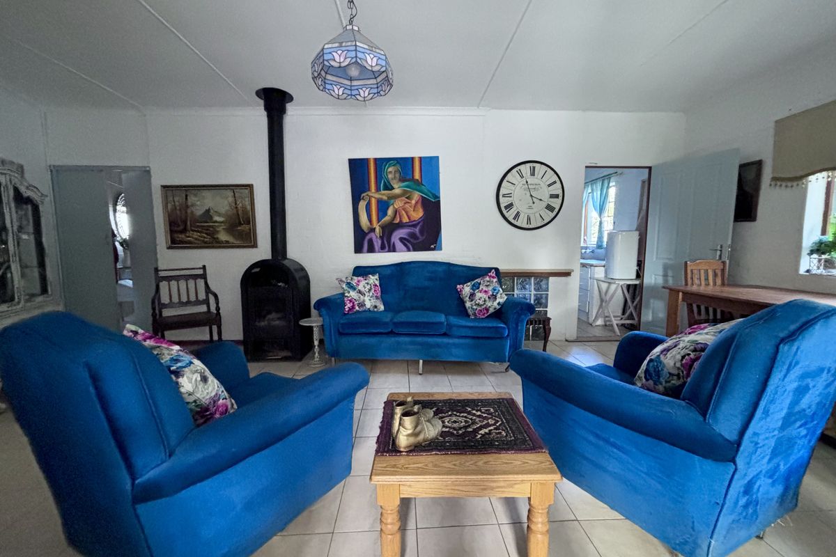 A living room featuring a freestanding fireplace and tiled flooring, providing a functional space with potential for modern updates.