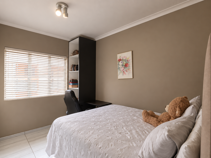 A well-maintained bedroom featuring neutral wall tones, tiled flooring, built-in wardrobe, and a functional built-in shelving unit with integrated desk space.