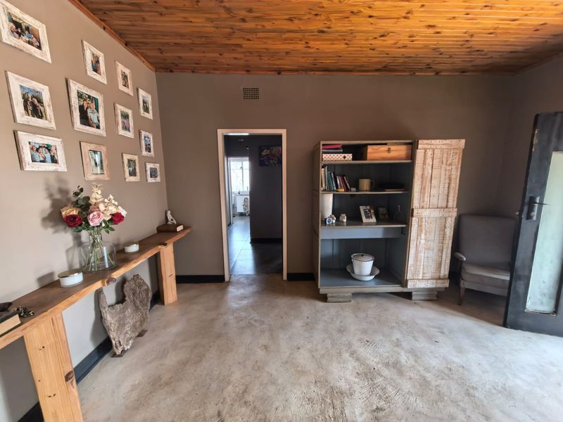 Living area featuring a rustic timber tongue and groove ceiling and polished concrete flooring, providing a neutral base for interior updates.