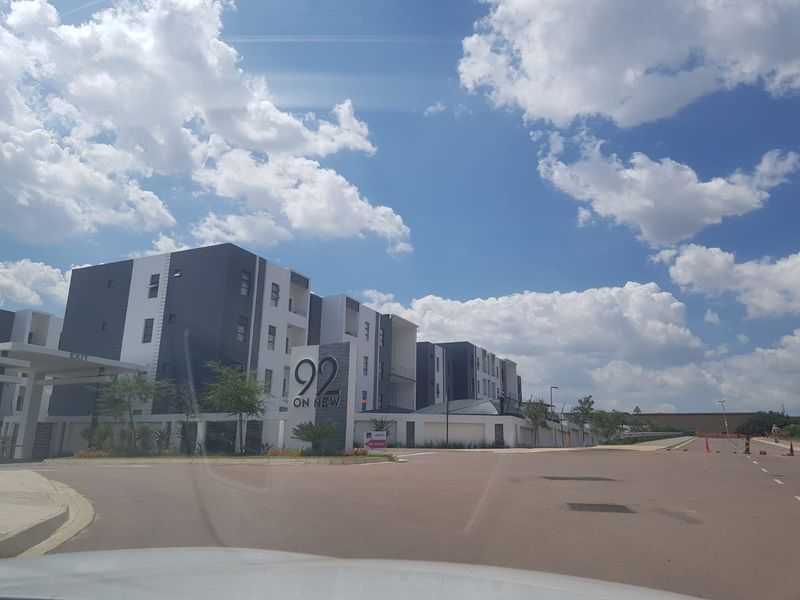 Street view of the modern 92 on New apartment complex, featuring contemporary architectural design and paved entrance area.