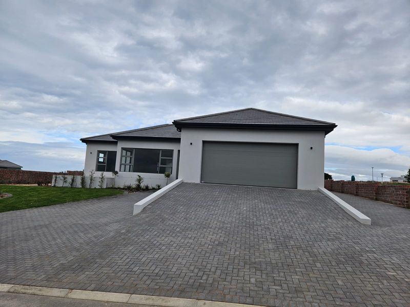 Modern single-story residential home featuring a paved driveway, double garage, and contemporary exterior finishes.