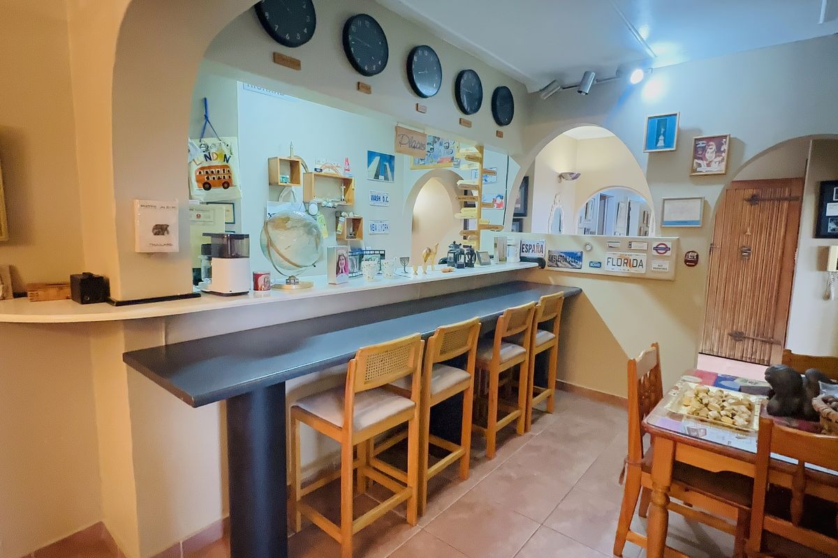 A kitchen area featuring a built-in breakfast bar with an arched opening, tiled flooring, and recessed lighting.