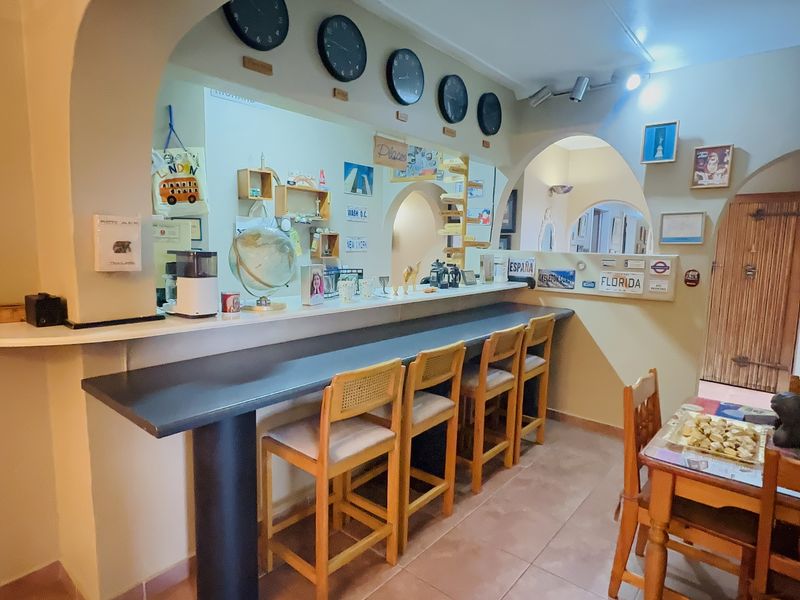 A kitchen area featuring a built-in breakfast bar with an arched opening, tiled flooring, and recessed lighting.