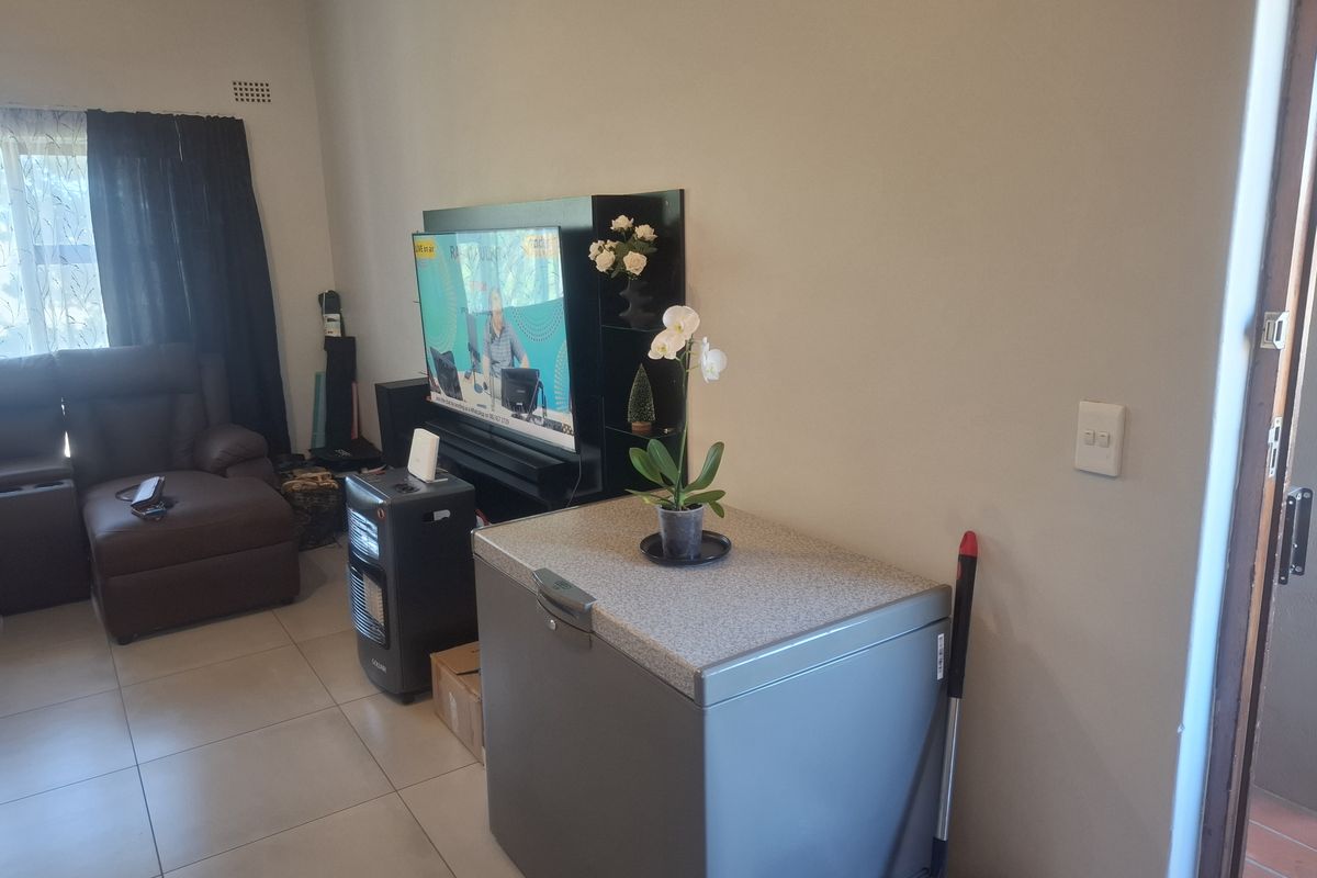 A living room area featuring tiled flooring and neutral wall finishes, providing a functional space for daily living.