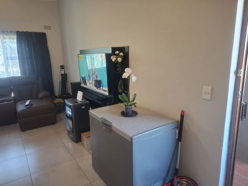 A living room area featuring tiled flooring and neutral wall finishes, providing a functional space for daily living.