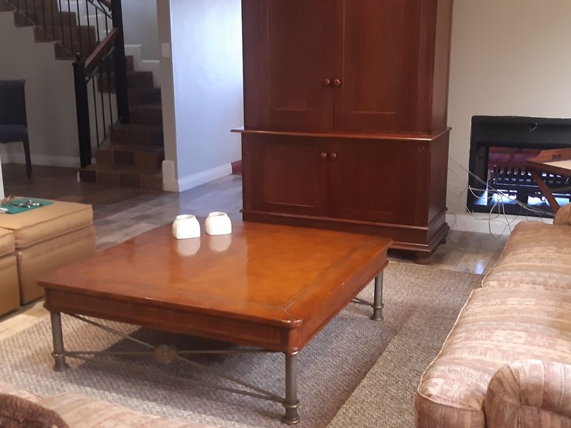 A comfortable living room featuring a built-in fireplace, laminate flooring, and an open staircase leading to the upper level.