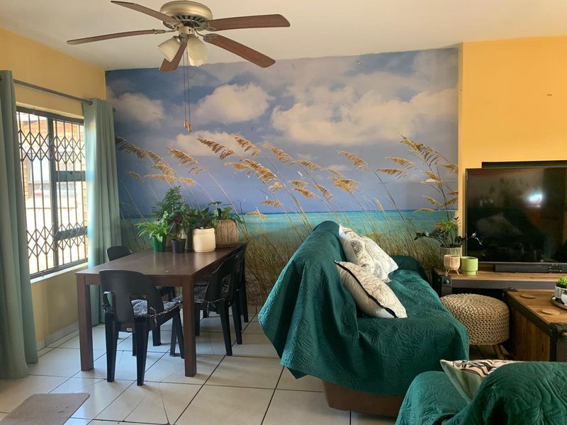 Open plan living and dining area featuring tiled flooring, a ceiling fan, and a large feature wall mural.