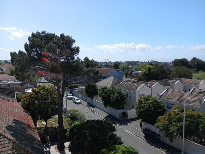 An elevated view overlooking the surrounding residential neighbourhood, street, and mature trees.