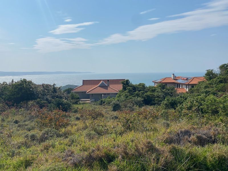 A scenic view overlooking the coastal landscape and ocean from the residential land plot.