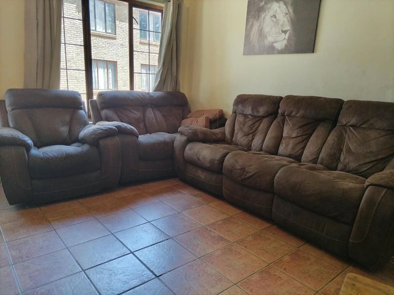 A living room area featuring tiled flooring and a large window providing natural light.