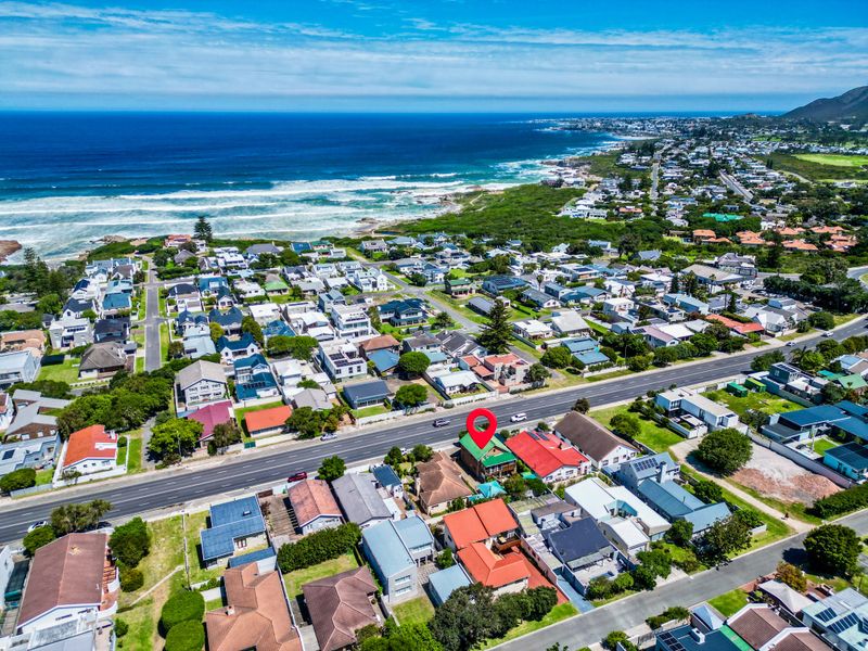 An aerial view of the coastal residential property, highlighting its proximity to the ocean and surrounding neighborhood infrastructure.