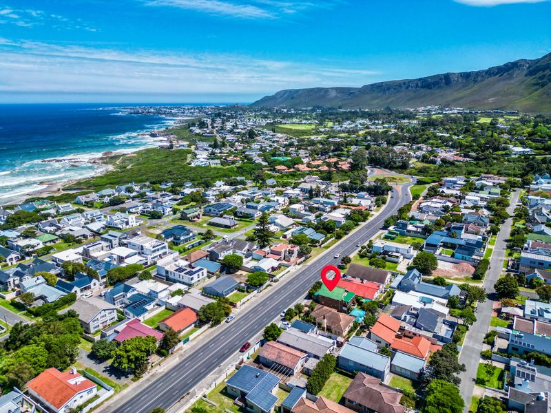 Aerial view of the property situated in a coastal neighborhood with mountain views and proximity to the ocean.