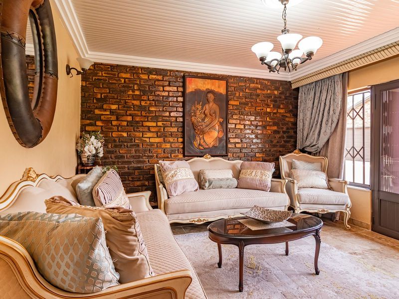 A cozy living room featuring an exposed brick accent wall, tongue and groove ceiling, and direct access to the exterior through a glass panel door.