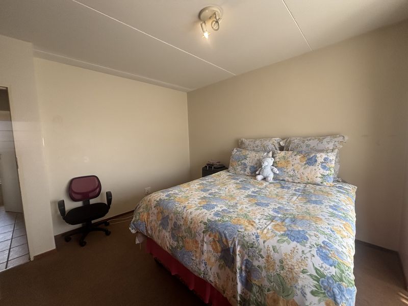 A standard bedroom featuring neutral wall finishes, carpeted flooring, and a central ceiling light fixture.