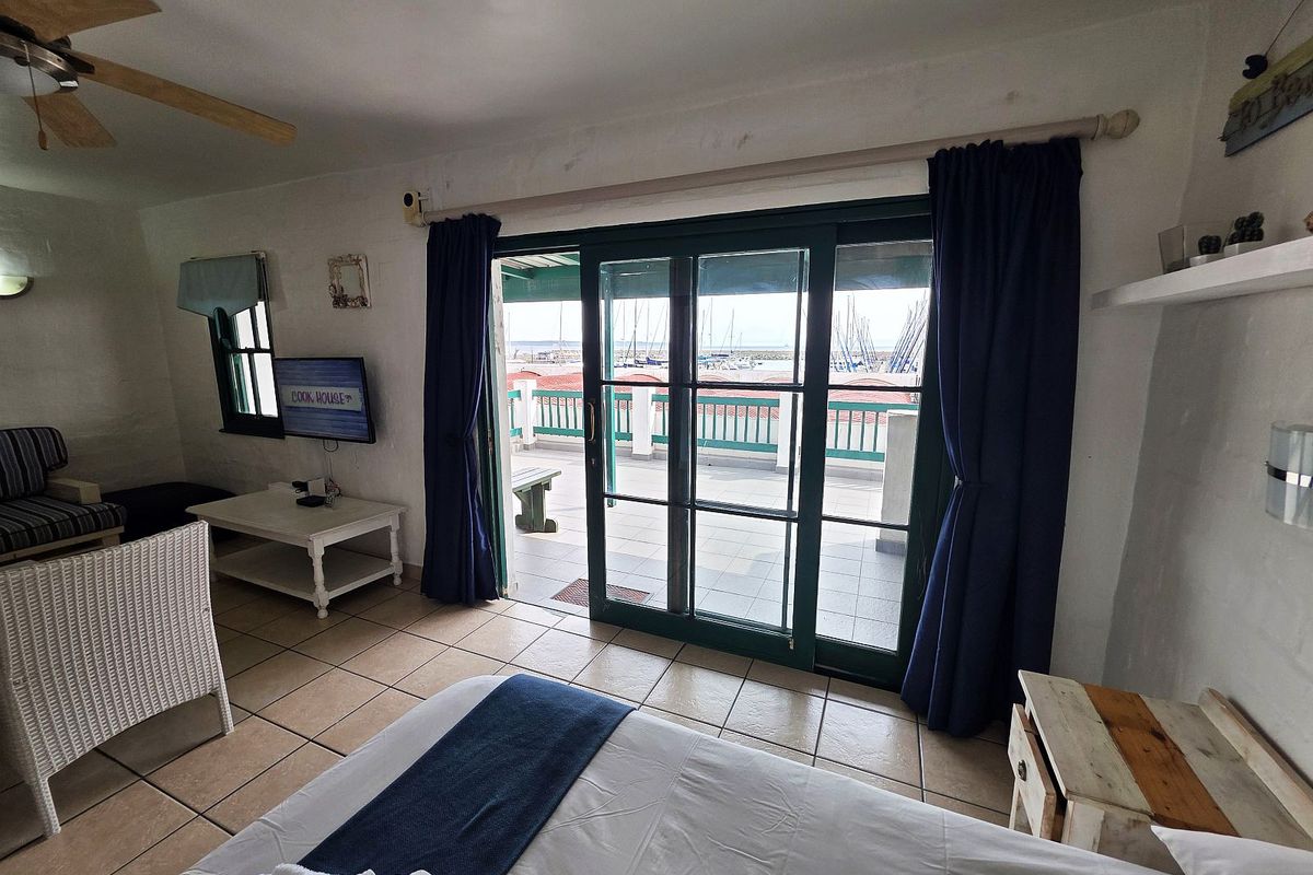 Bedroom featuring tiled flooring, a ceiling fan, and large sliding glass doors providing access to a balcony with marina views.