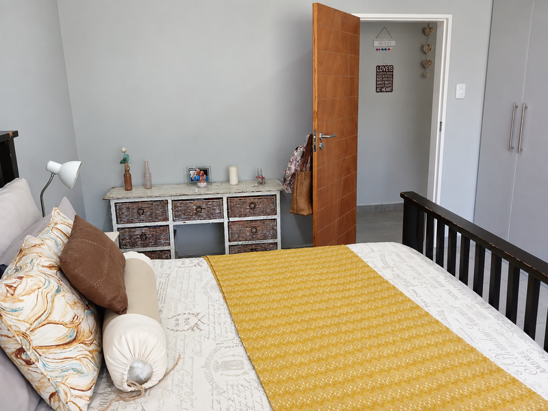 A well-maintained bedroom featuring built-in cupboards, neutral wall finishes, and a solid wooden door leading to an adjacent space.