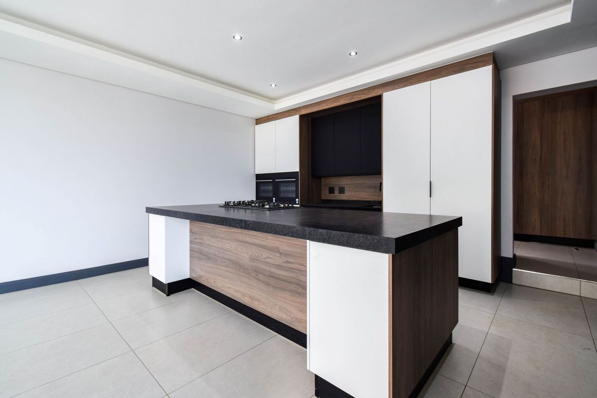 Modern kitchen featuring a central island with a built-in gas hob, sleek cabinetry, and integrated appliances in a clean, contemporary design.