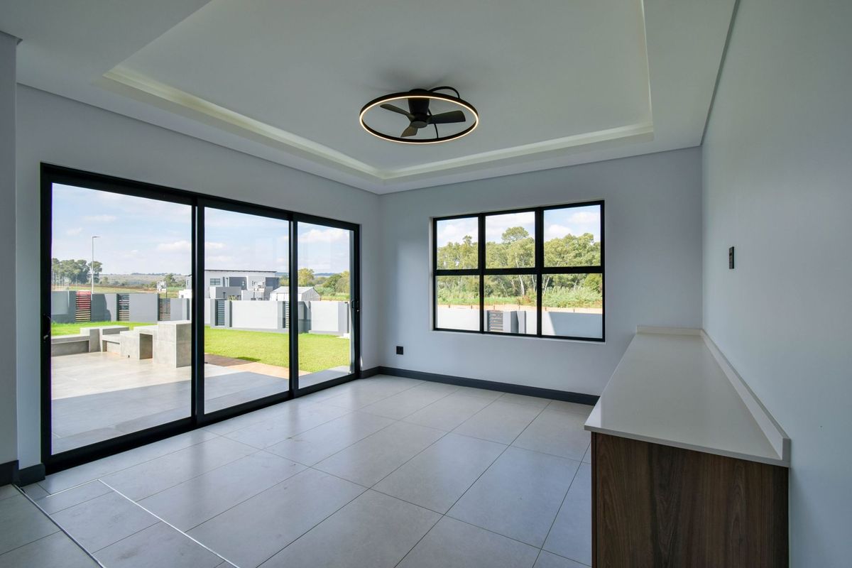 Bright living area featuring large sliding glass doors, modern recessed ceiling lighting, a contemporary ceiling fan, and sleek tiled flooring.