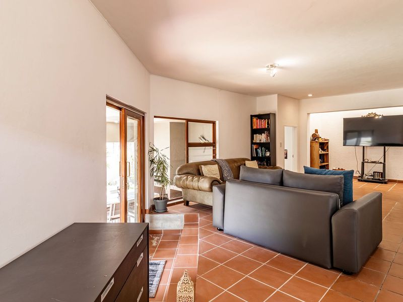 Spacious living area featuring terracotta floor tiles, recessed lighting, and large sliding glass doors providing access to the outdoor space.