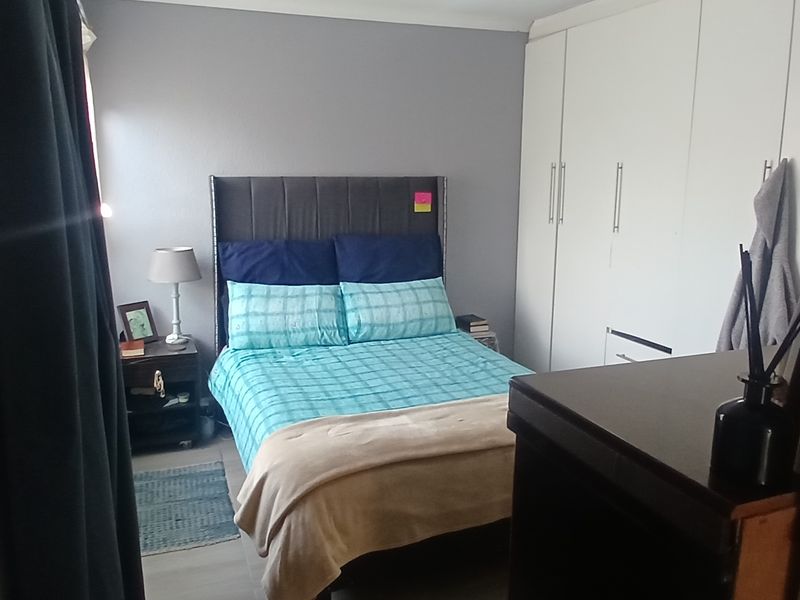 A functional bedroom featuring built-in cupboards and neutral wall finishes, providing a comfortable and practical sleeping space.
