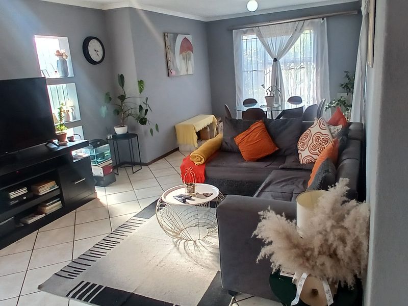 A comfortable living room featuring tiled flooring and built-in wall niches, providing a functional and well-lit space for relaxation.