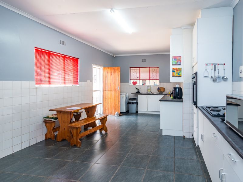 A functional kitchen featuring built-in cabinetry, dark laminate countertops, a built-in oven, gas hob, and tiled flooring with a tiled splashback.