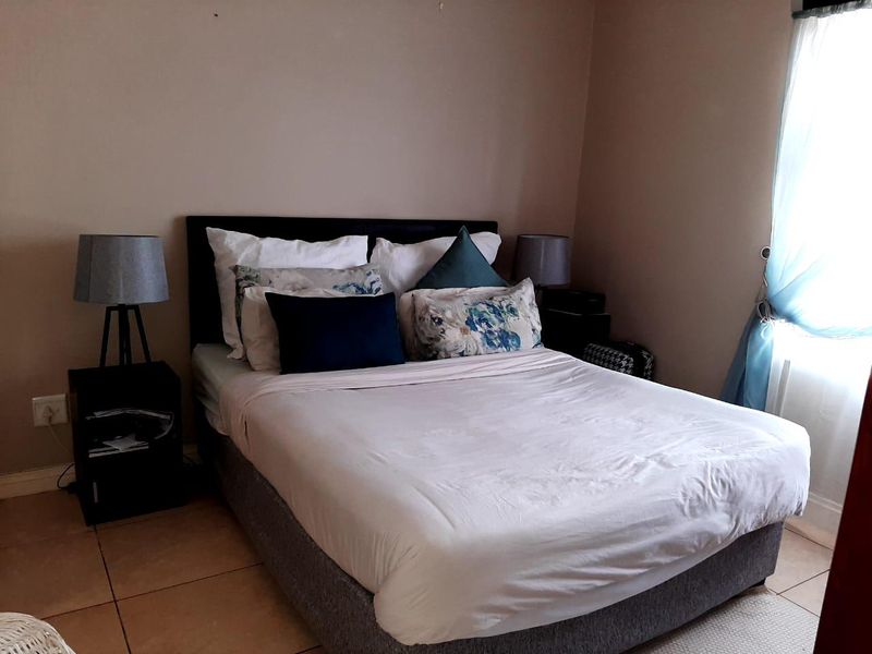 A bedroom featuring tiled flooring and a window, providing a functional space for rest.
